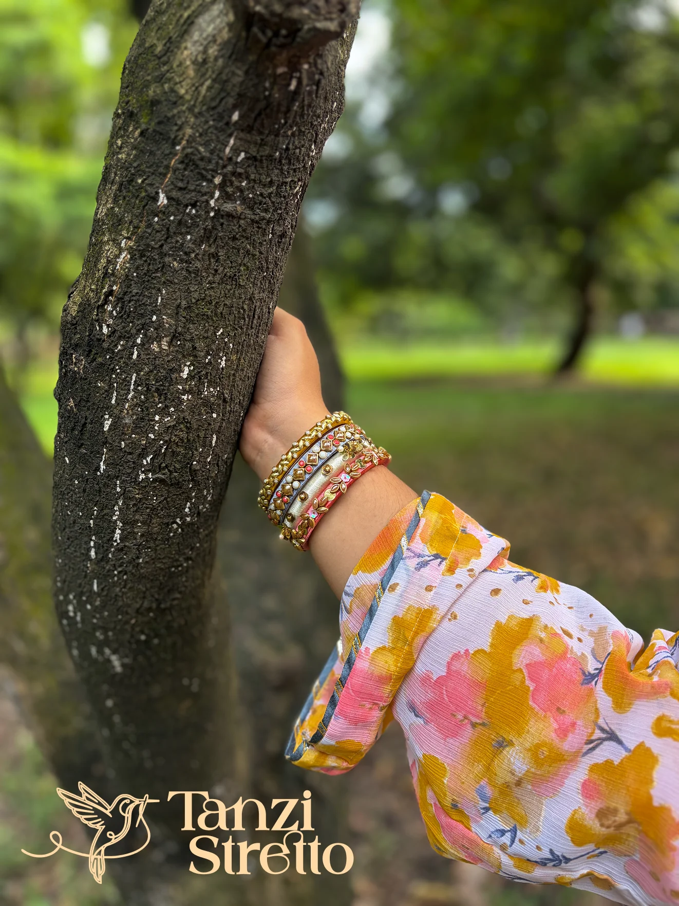 Roddur bangles worn outdoors, hand resting on a tree