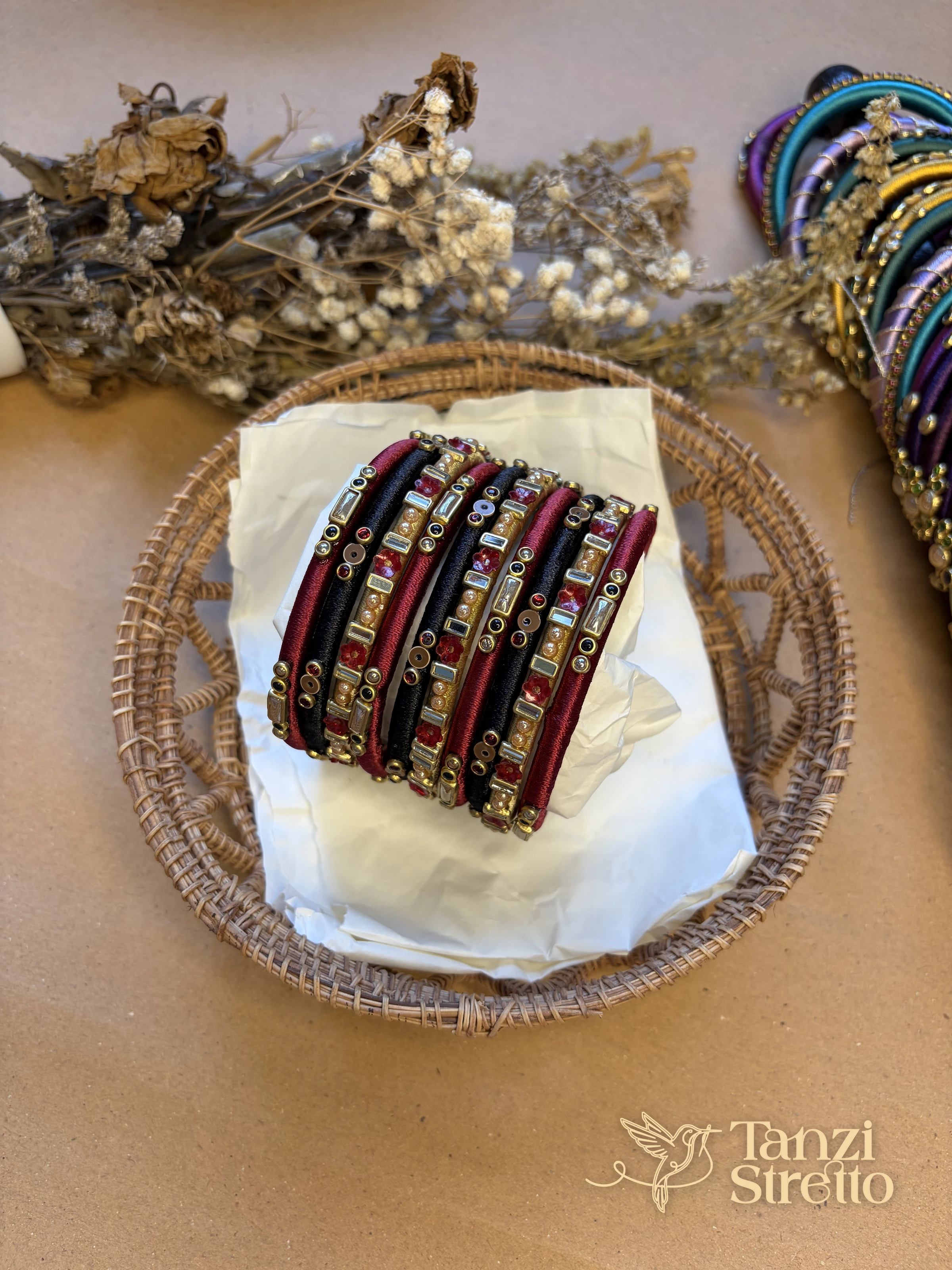 Anonya 2.0 maroon, black and gold silk thread bangles in a woven basket