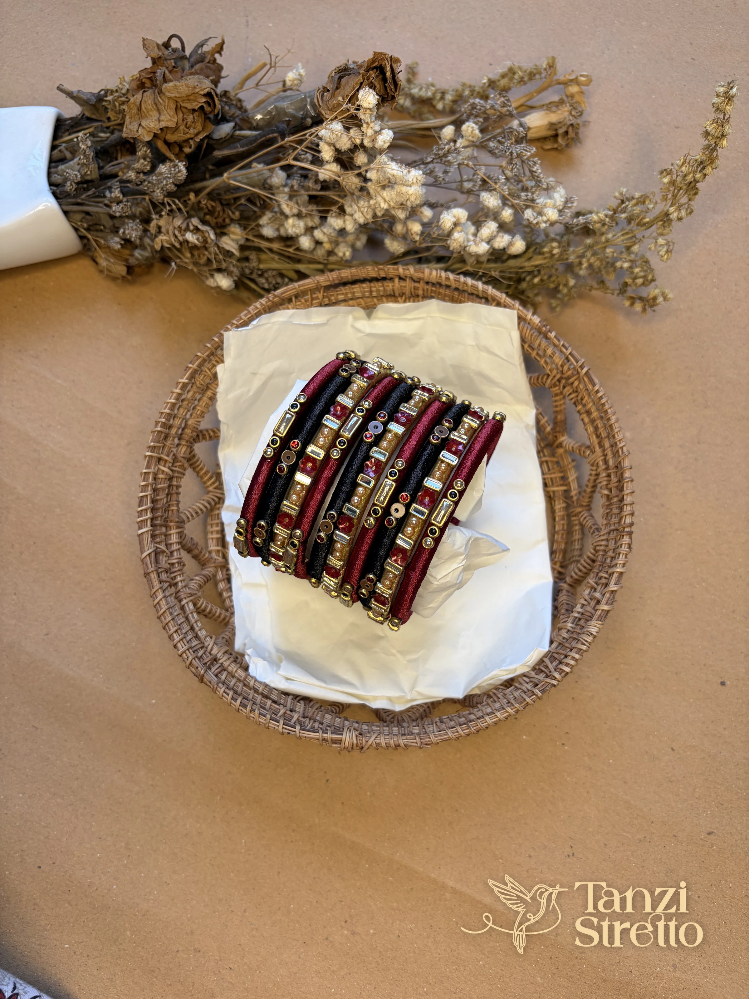 Anonya 2.0 bangles from above in a basket with dried flowers