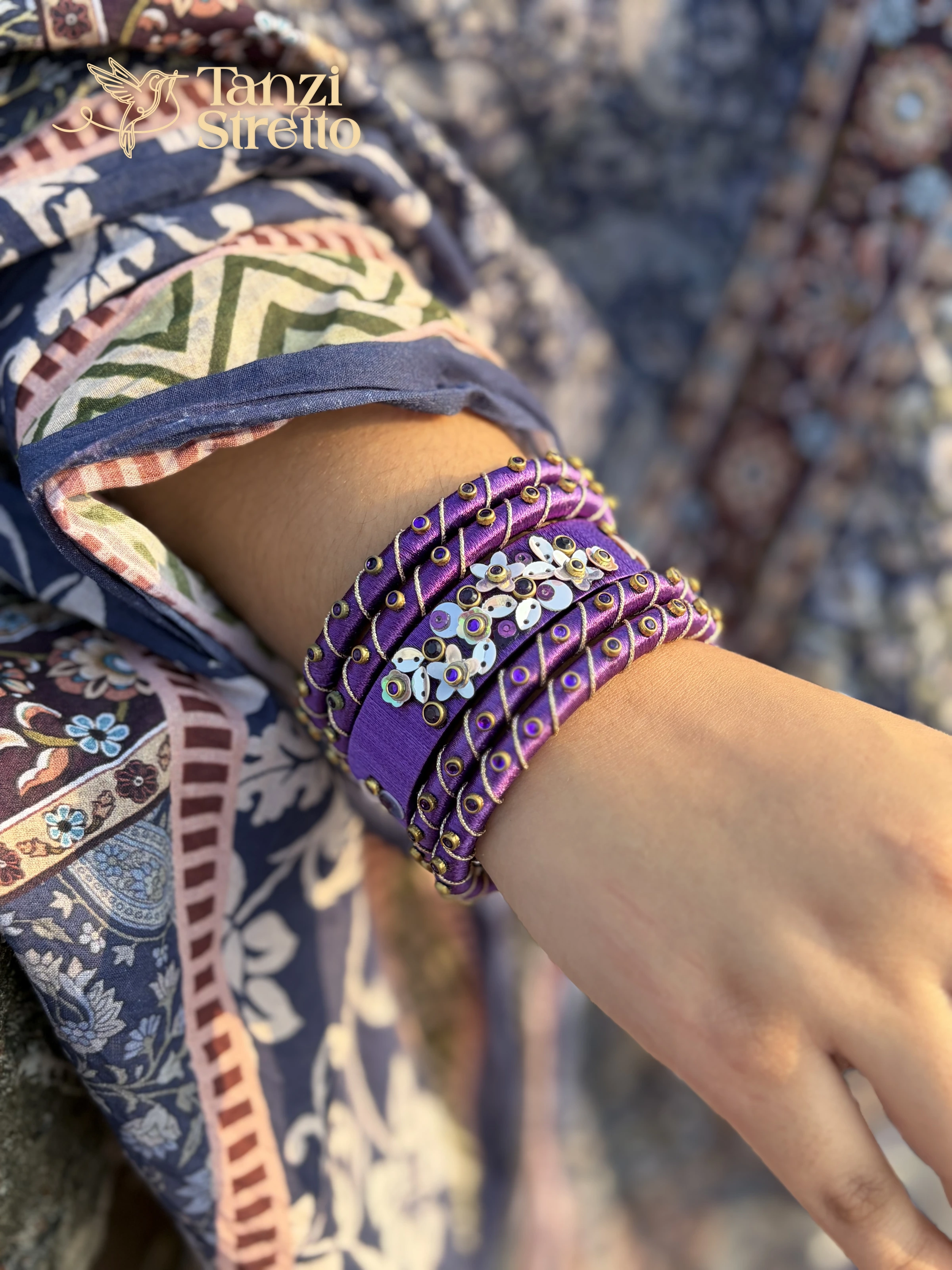 Jarul violet silk thread bangles with white flower sequins on a wrist