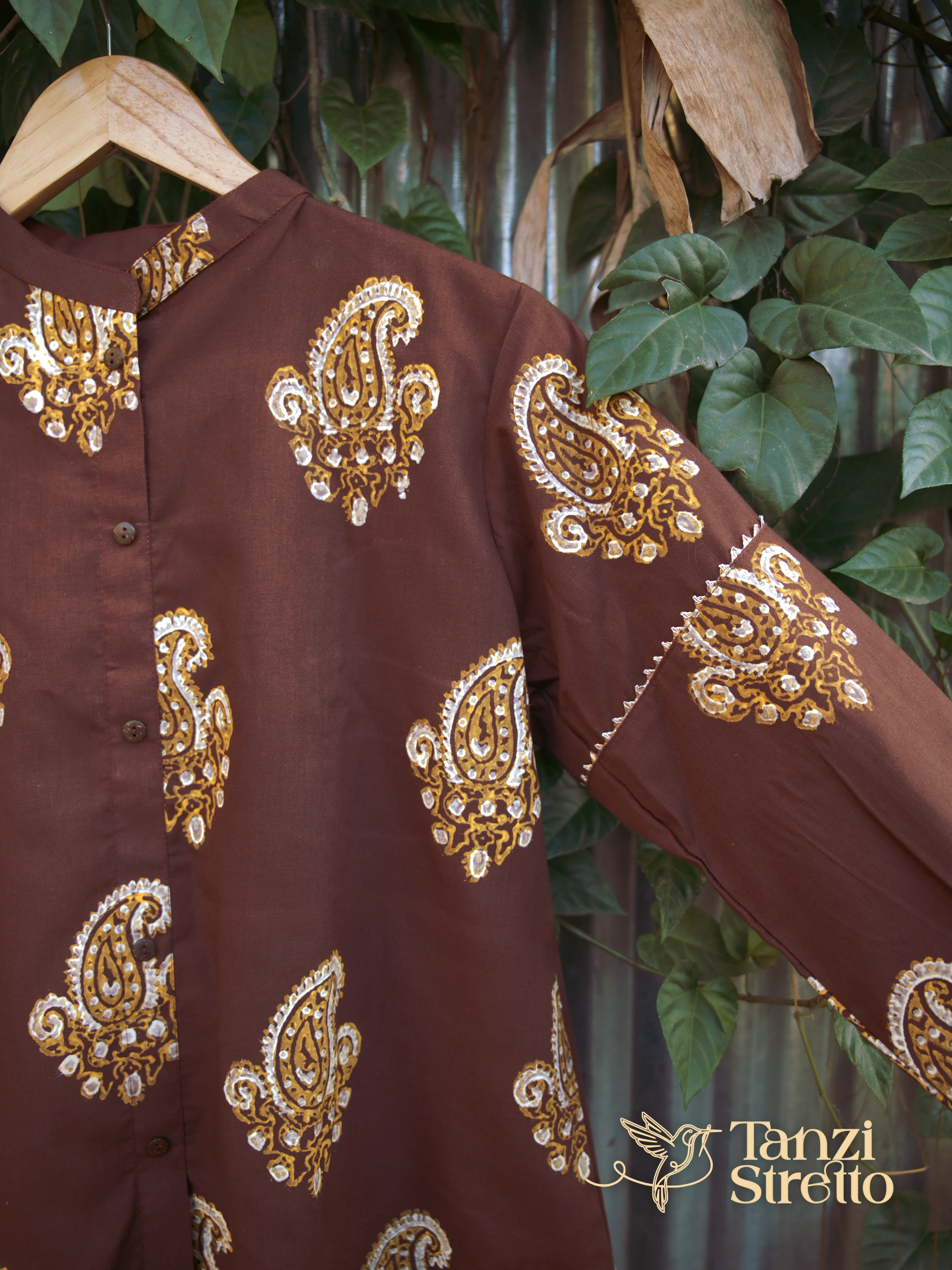 Milind front on a hanger: full button placket and paisley print