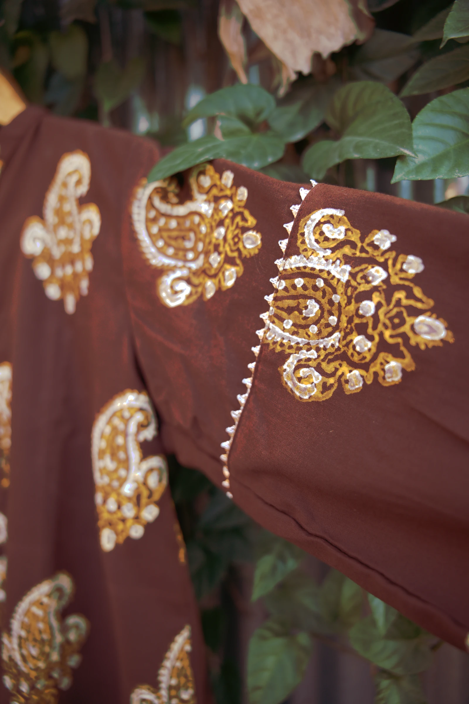 Close-up of the cream trim along the shoulder seam and a paisley on the sleeve