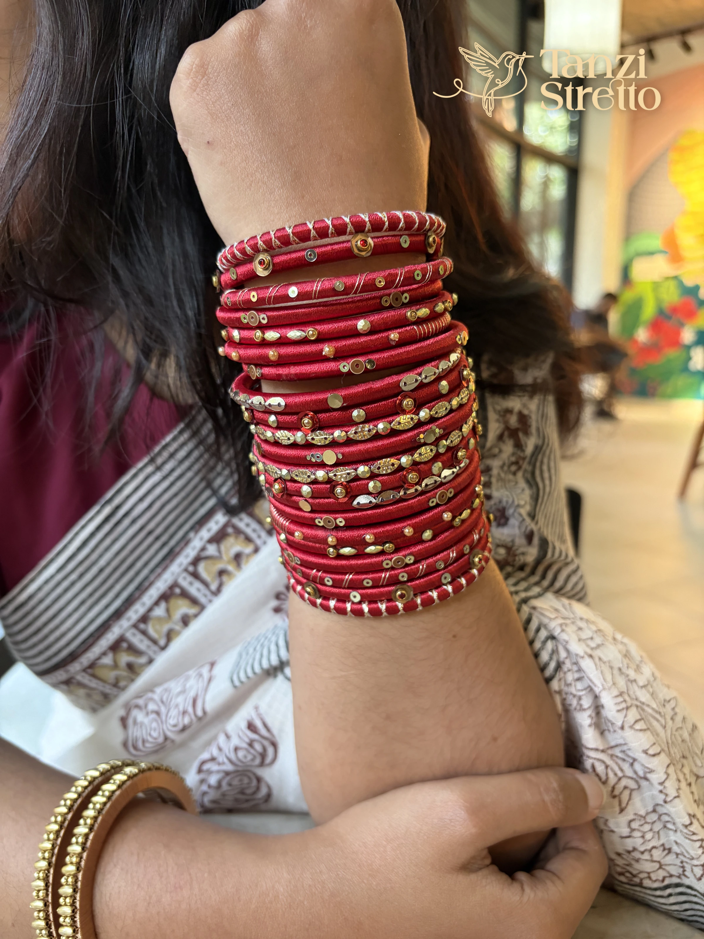Obhishar stack worn high on the arm with a white saree